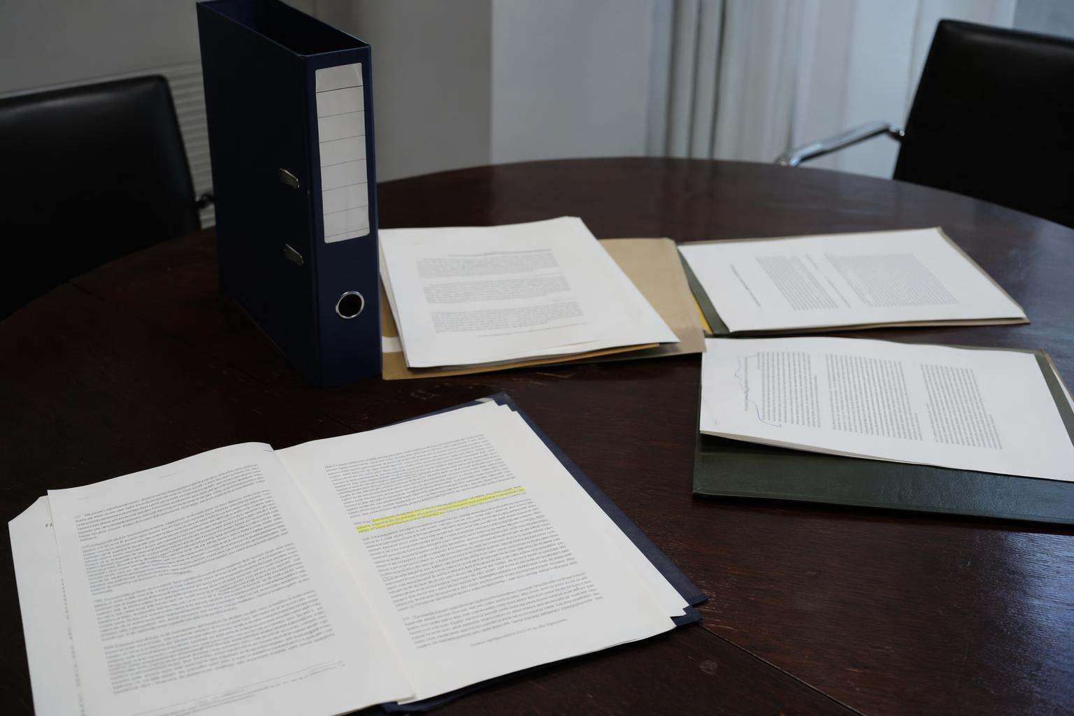Mesa de junta con expedientes de defensa ante la Audiencia Nacional en despacho de abogados penalistas