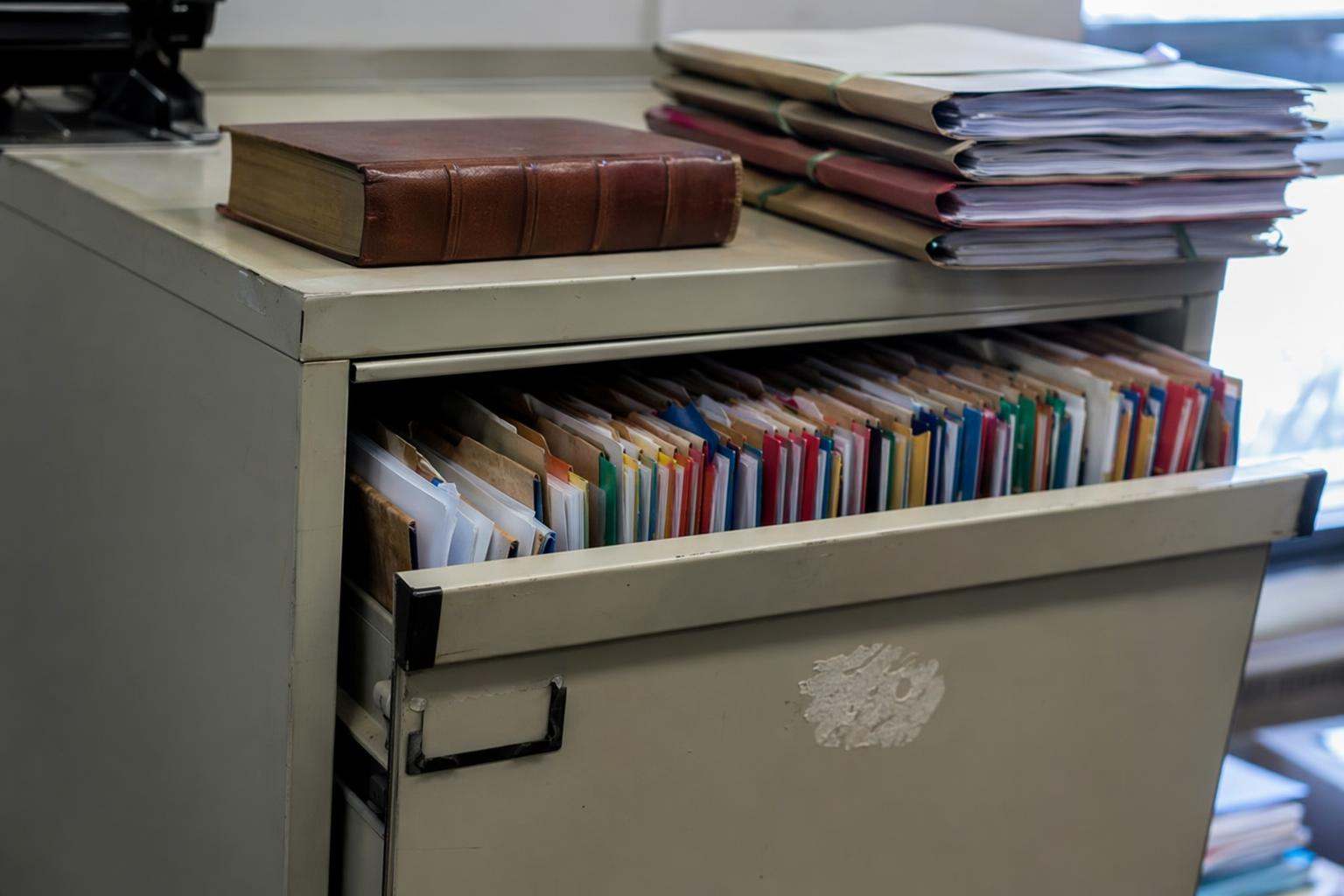 Archivador con expedientes apilados y código penal encima, abogados penalistas Burgos