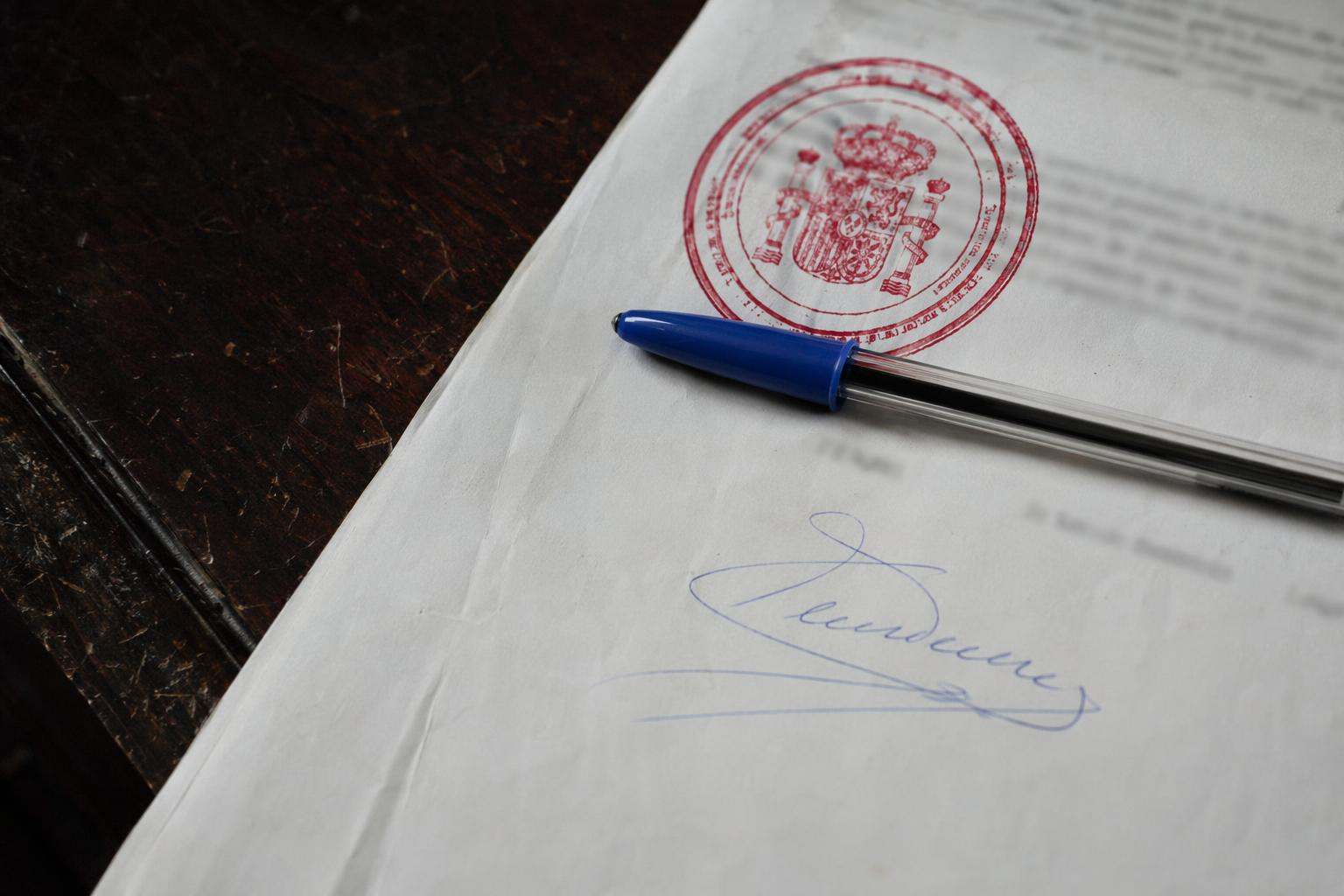 Sello procesal rojo sobre escrito firmado con BIC — despacho abogados penalistas Castellón