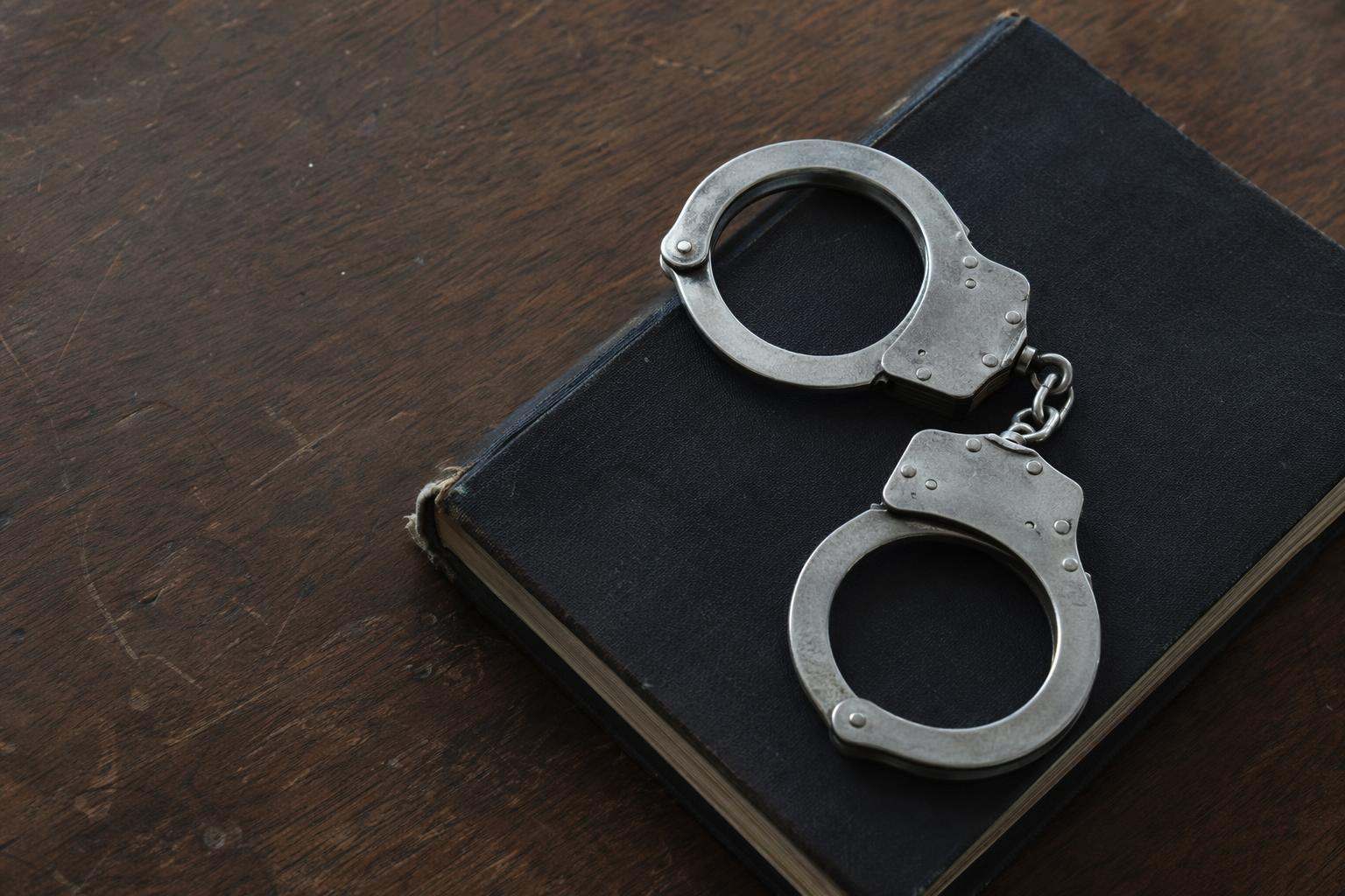 Esposas sobre código penal cerrado encuadernado — despacho abogados penalistas Girona