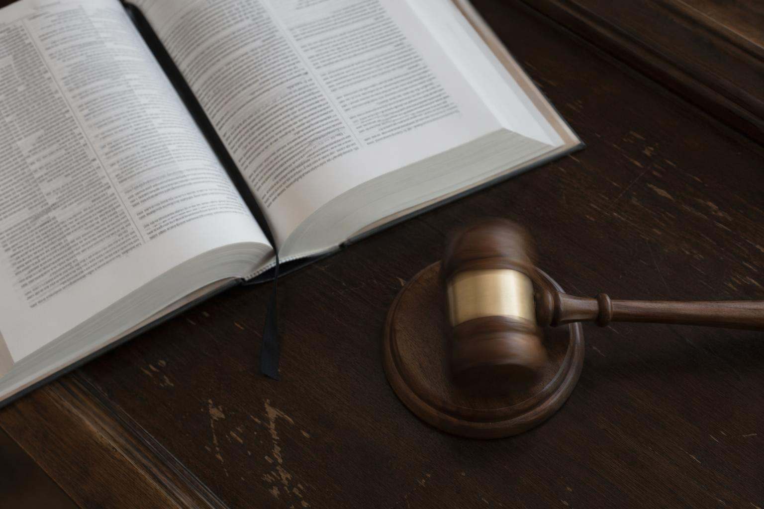 Mazo de juez sobre código penal abierto en mesa de juzgado, despacho penal en León