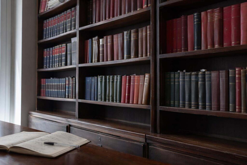 Escritorio de abogados penalistas en Oviedo con expediente penal anotado y vista desfocada de tejados del casco antiguo