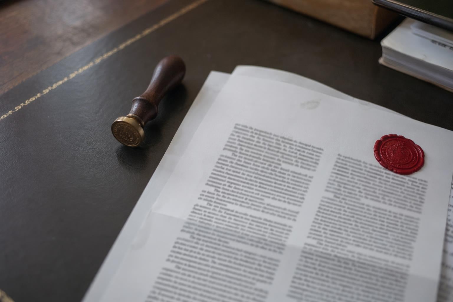 Sello procesal rojo sobre escrito A4 en despacho de abogados penalistas en Sevilla
